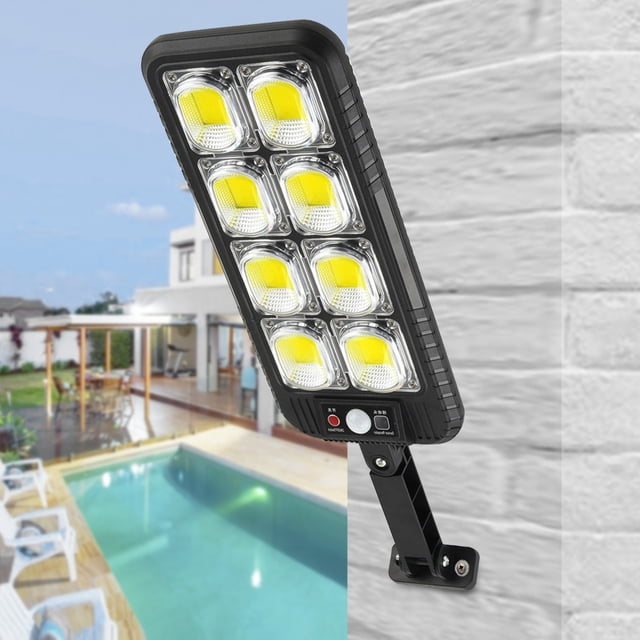 luz exterior con sensor de movimiento, lámpara solar de control remoto 200 COB para jardín y patio multicolor panel rectangular con ocho módulos COB visibles y carcasa negra, soporte articulado montado en muro, botón y sensor frontal; incluye detección por microondas y se utiliza a menudo para iluminar caminos o rincones oscuros de jardín.