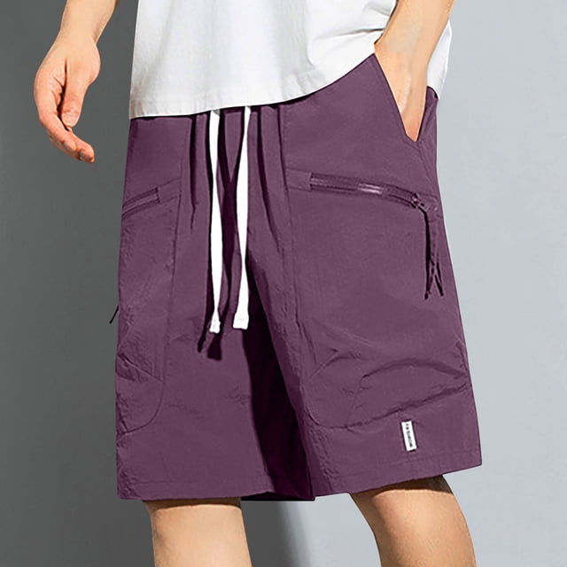 fiudx pantalones cortos para hombre, pantalones de fitness ligeros color morado; vista frontal centrada hasta la rodilla, cintura elástica con cordón blanco, bolsillos laterales con cremallera y costuras visibles, tela lisa y transpirable ideal para correr en el gimnasio, estilo de vida activo y moda primavera; también suelen usarse para entrenamiento general o uso casual.