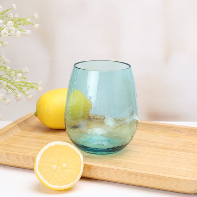 Mainstays Hammered Blue Acrylic Stemless Wine Glass, 498 mL, 1 Pack, shown front and center on a wooden tray with a hammered texture and blue tinted acrylic construction, paired with a whole lemon and lemon half, suitable for durable barware use indoors or outdoors.