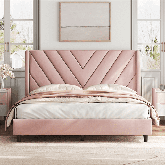Pink queen upholstered platform bed frame with chevron-patterned headboard and wooden slat support in bright room.