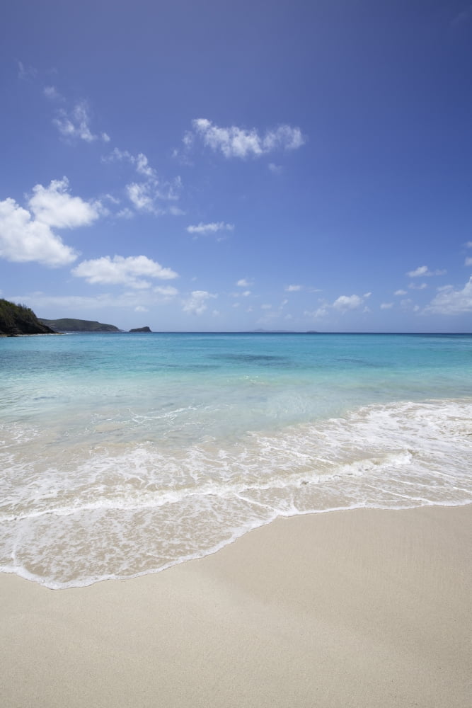 White sand island beach with crystal clear turquoise water and blue sky