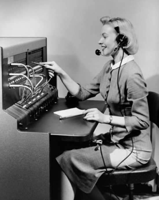 Side profile of female telephone operator operating telephone