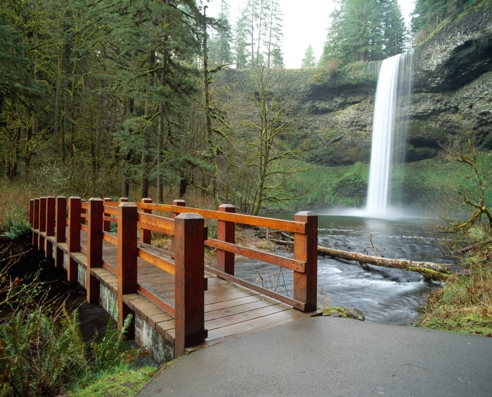 Footbridge across a river with a waterfall in the background Silver