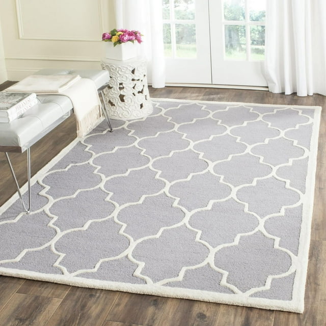 Safavieh Cambridge Kevin gray area rug featuring a white geometric trellis pattern on wood flooring near a bench and decorative stool.