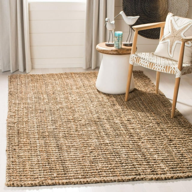Safavieh Levi braided natural fiber area rug displayed in a bright room with wooden floor, next to a woven chair and round side table.