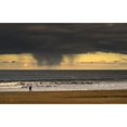 thumbnail image 2 of Silhouette of a person and dog walking on the beach at the water's edge under storm clouds with rain streaks and a sunse, 2 of 4