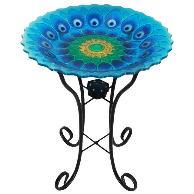 Angelo Décor 23.3-inch tall peacock glass birdbath with vibrant blue, green, and yellow feather design on a black metal stand with curled legs and integrated solar light.