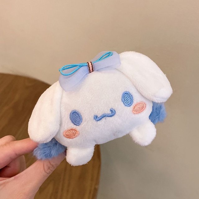 clip para la garra de pelo de eula sanrio kuromi melody cinnamoroll pinzas grandes tocado mujeres accesorios para el cabello Nuevo peluche 12 cm, vista frontal centrada de Cinnamoroll blanco con ojos y mejillas bordadas en azul y rosa, lazo de organza azul en la parte superior, orejas acolchadas y base de garra lateral visible sobre fondo interior neutro. También suele usarse para sujetar mechones al peinarse.