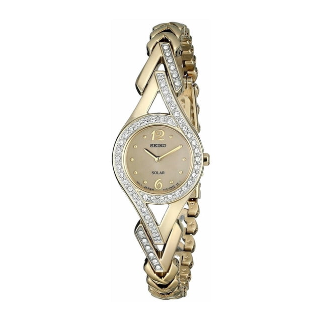 seiko sup176 solar swarovski crystal accent reloj para mujer con esfera dorada reloj Seiko solar para mujer con caja redonda dorada y bisel con cristales Swarovski; esfera champán con numerales 12 y 6, manecillas doradas y brazalete de eslabones pulido con cierre desplegable, vista frontal sobre fondo blanco. A menudo usado como accesorio de joyería para ocasiones formales.