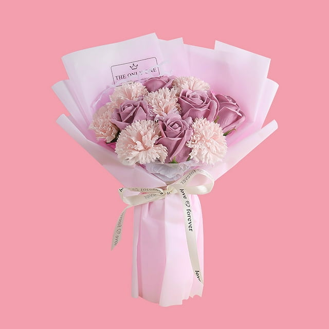 fiudx ramo de flores preservadas en jabón tamaño 33 cm, vista frontal centrada de arreglo envuelto en papel rosa con lazo crema; claveles pálidos y rosas morado #3 con aspecto realista y textura mate, arreglo compacto para decoración del hogar, regalo para el Día de la Madre y uso en bodas y fiestas.