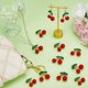 thumbnail image 4 of 12 colgantes grandes de cereza roja, de aleación dorada con diamantes de imitación verdes y plástico. Colgantes de cereza roja, bonitos colgantes de frutas, adorno decorativo., 4 of 5