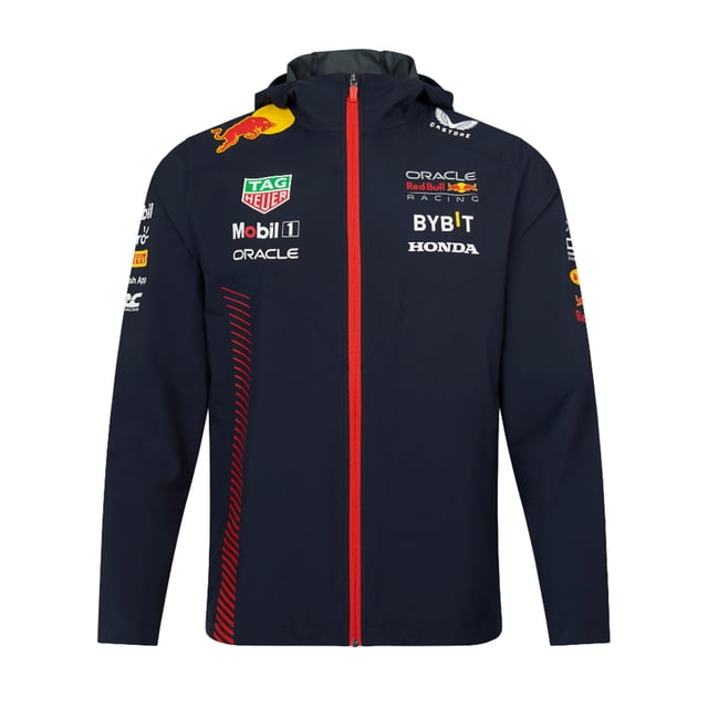 chamarra impermeable Azul Marino Red Bull Racing con capucha, vista frontal centrada y cierre rojo central. Silueta recta en 100% poliéster; logotipos estampados de equipo y patrocinadores en pecho y mangas, ribete en los puños y panel lateral con gráfico rojo. Impermeable y adecuada para uso en lluvia ligera o desplazamientos.