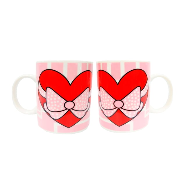 set 2 tazas ceramica genérica corazon moño Set de dos tazas de cerámica multicolor de la marca Generica, vista frontal centrada; cada taza muestra un gran corazón rojo con un moño rosa con puntos sobre fondo rosa a rayas, asas visibles, diseño en ambos lados, ideales para café o té y para regalar.
