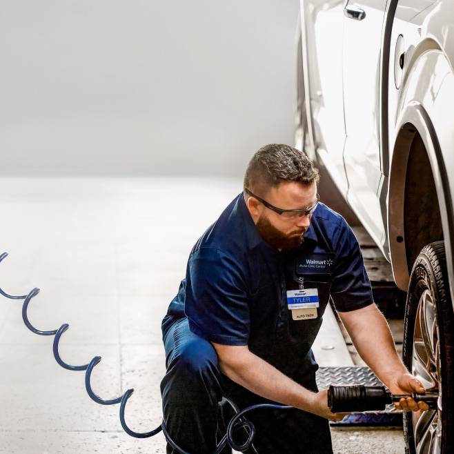 A person working on the wheel of a car.