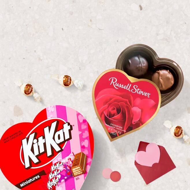 A heart-shaped KitKat box is shown next to a Russell Stover heart-shaped chocolates box