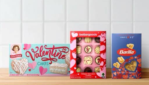 A box of Little Debbie Valentine cakes is shown next to a bettergoods chocolate assortment box, with Barilla heart-shaped pasta.
