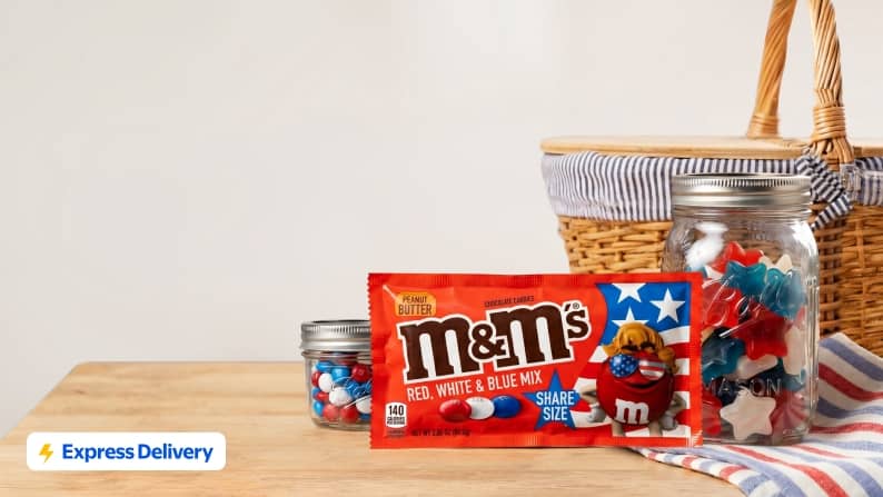 Express Delivery. Red, white, and blue peanut butter share size M and M’s next to red, white, and blue gummy stars and a picnic basket.