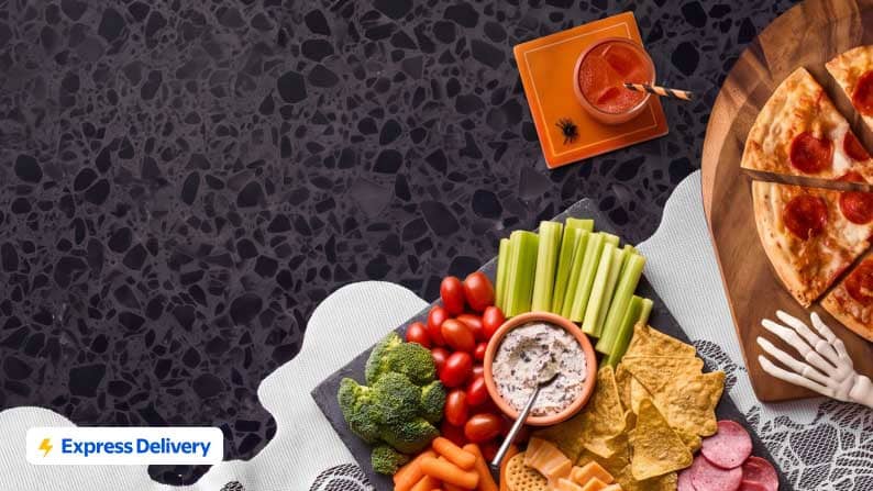 Express Delivery badge with party snacks, fresh vegetables, dip, tortilla chips and a pepperoni pizza slice on a tabletop.