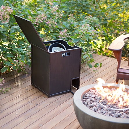 A fuel cover opened with a propane tank hidden inside next to a gas fire pit.