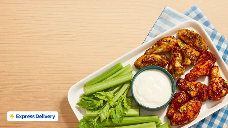 Express Delivery is subject to availability. Restrictions and fees apply. A plate of chicken wings is pictured with celery sticks and ranch dressing.