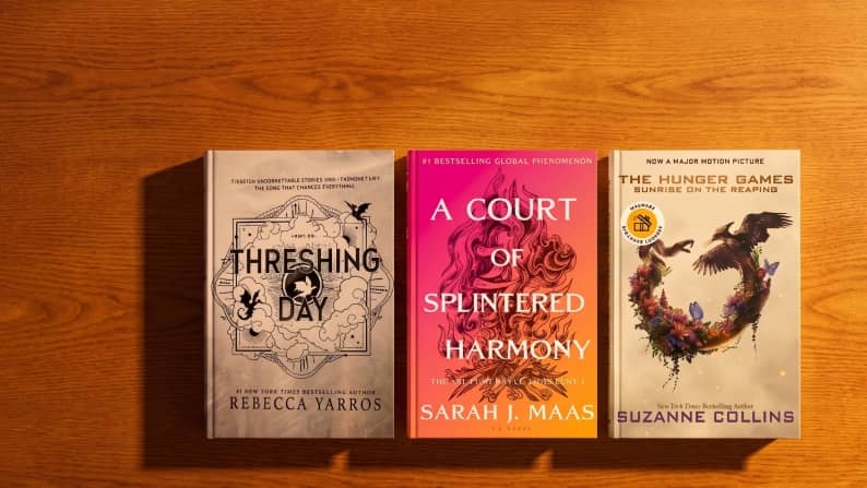 Three fantasy hardcovers: Threshing Day by Rebecca Yarros, A Court of Splintered Harmony by Sarah J. Maas, The Hunger Games Sunrise on the Reaping.