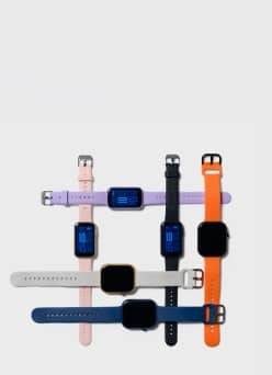 Grid arrangement of colorful smartwatches with silicone straps in pink, purple, black, orange, grey and navy blue.