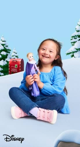 Girl shown playing with Elsa doll against a snowy background. Disney logo also shown.