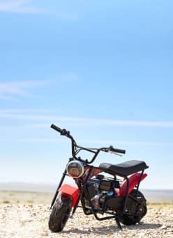 A motorbike parked on a rocky road.