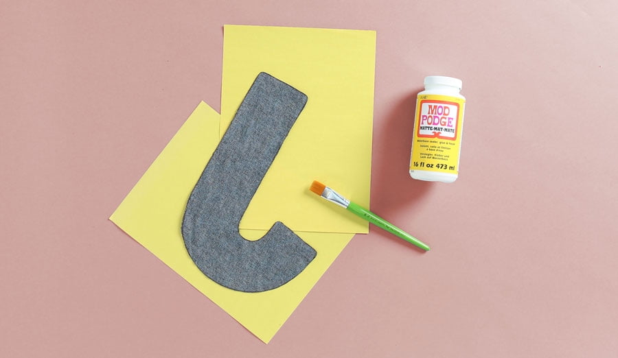 applying mod podge on back of fabric letter