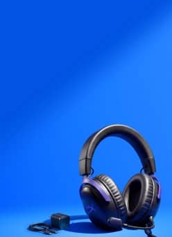 Black over ear gaming headset with purple accents, with a small black audio adapter and cable beside it.