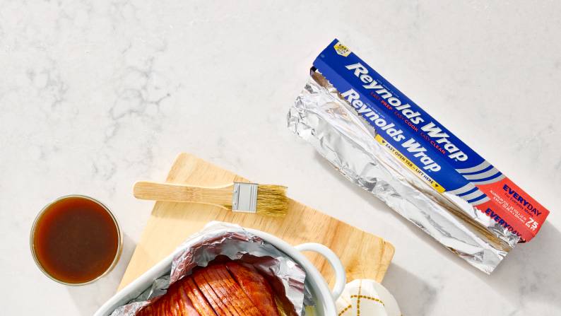Reynolds wrap on a countertop next to a freshly cooked ham.