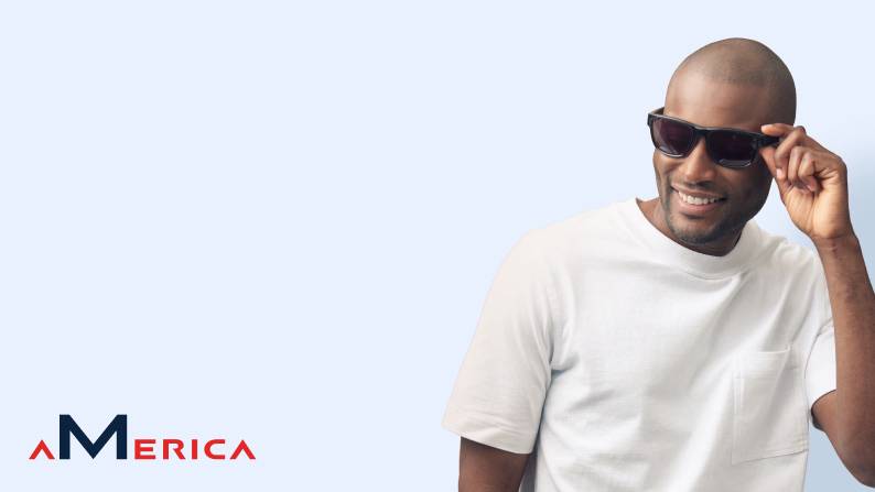 Man in a white shirt posing in stylish black sunglasses.