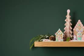 Shelf shown decorated with gingerbread houses with pink and green frosting as well as gingerbread trees also with pink and green frosting.