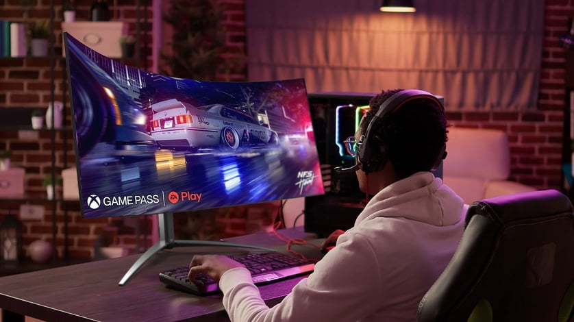 Person with hands on keyboard playing a video game with Xbox Gamepass.
