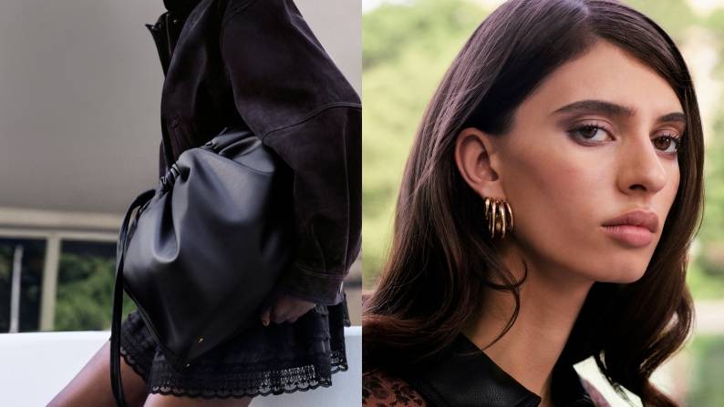 Woman wearing sculptural gold hoop earrings beside a black gathered, oversized cluth handbag.