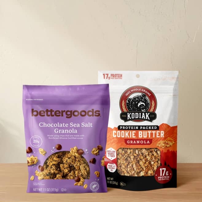 A package of bettergoods chocolate sea salt granola and Kodiak protein-packed cookie butter granola sit on a kitchen counter.