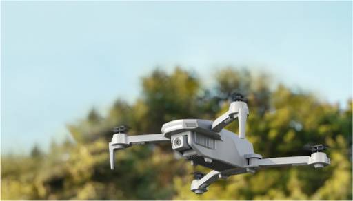 Image of a white drone flying outside.