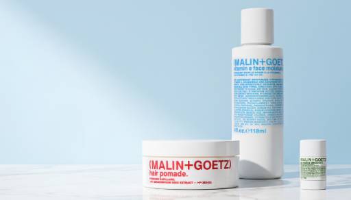 Trio of Malin and Goetz products including hair pomade, face moisturizer and deodorant.