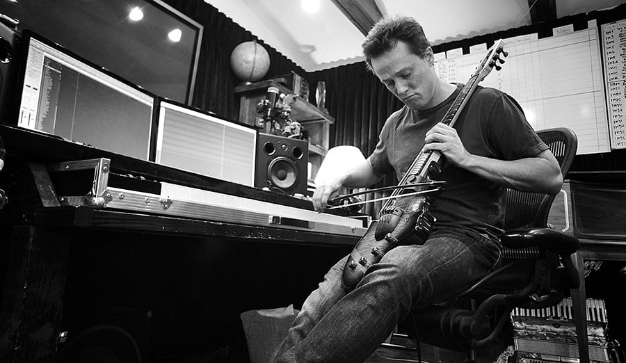 Nathan Barr playing the violin in a black and white photo