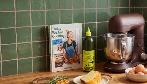 Today We Are Cooking cookbook, Graza bottle, mixer, sliced bread and eggs on a kitchen counter.