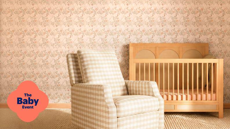 The Baby Event. A plaid upholstered nursery chair sits beside a wooden baby crib on a textured floor.