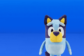 Image shows a large blue and purple Bluey plush toy on a blue background.