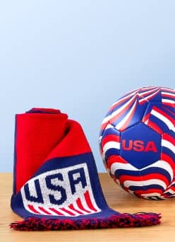 A variety of Team USA memorabilia is on a wooden counter—a scarf and a soccer ball.