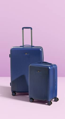 Two blue hard-shell rolling suitcases in different sizes standing upright against a soft pastel background.