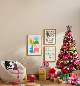 Room shown with a tree decorated with neon pink, green and silver decorations as well as gifts with neon pink and green wrapping.