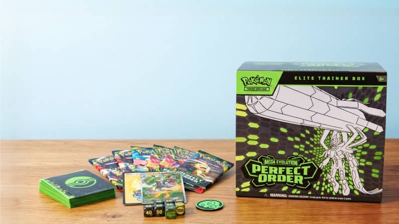 A box of Pokémon cards next to some loose Pokémon cards, dice and other paraphernalia.
