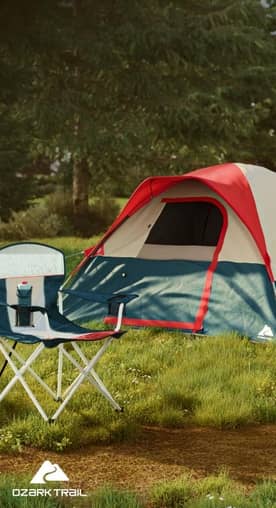 A blue tent, camp chair, and cooler on a green lawn next to a fire pit.