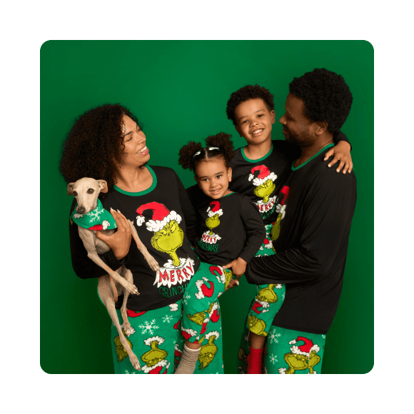 Mom, dad, kids and their little dog are all wearing matching festive pajamas.