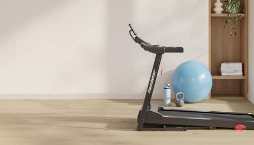 An image of a treadmill in a beige room with light wood floors. A bookshelf and balance ball are in the background.