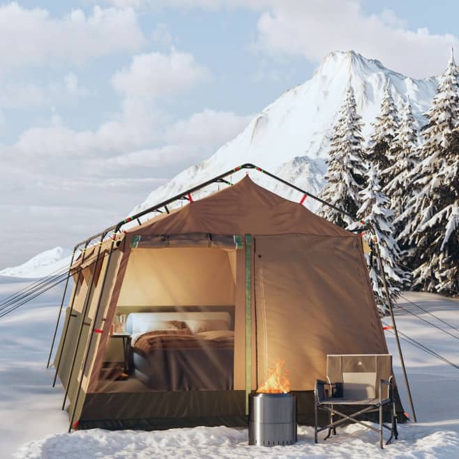 A tent, camping chair & fire pit among snow, mountains & trees